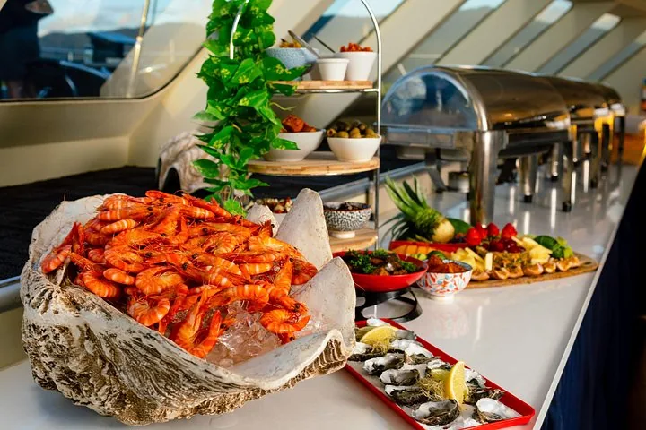 Buffet mit einer großen Schüssel Garnelen, Austern und anderen Gerichten auf dem Boot