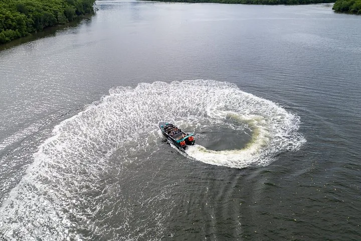 Luftaufnahme eines Jetboots, das eine kreisförmige Kielwelle auf dem Wasser zieht