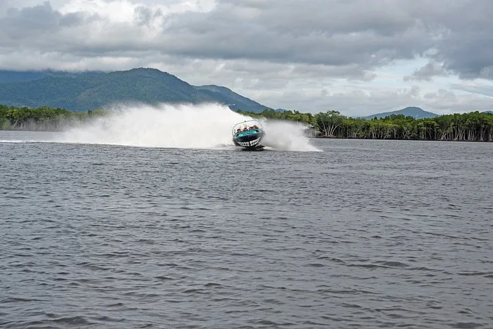 Jetboat speeding towards the camera, kicking up a large splash